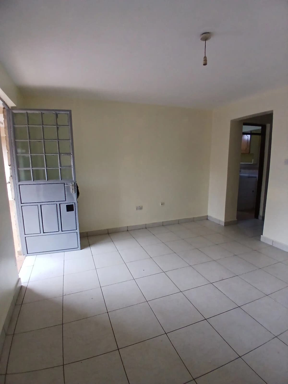 Empty living space with tiled flooring and natural light