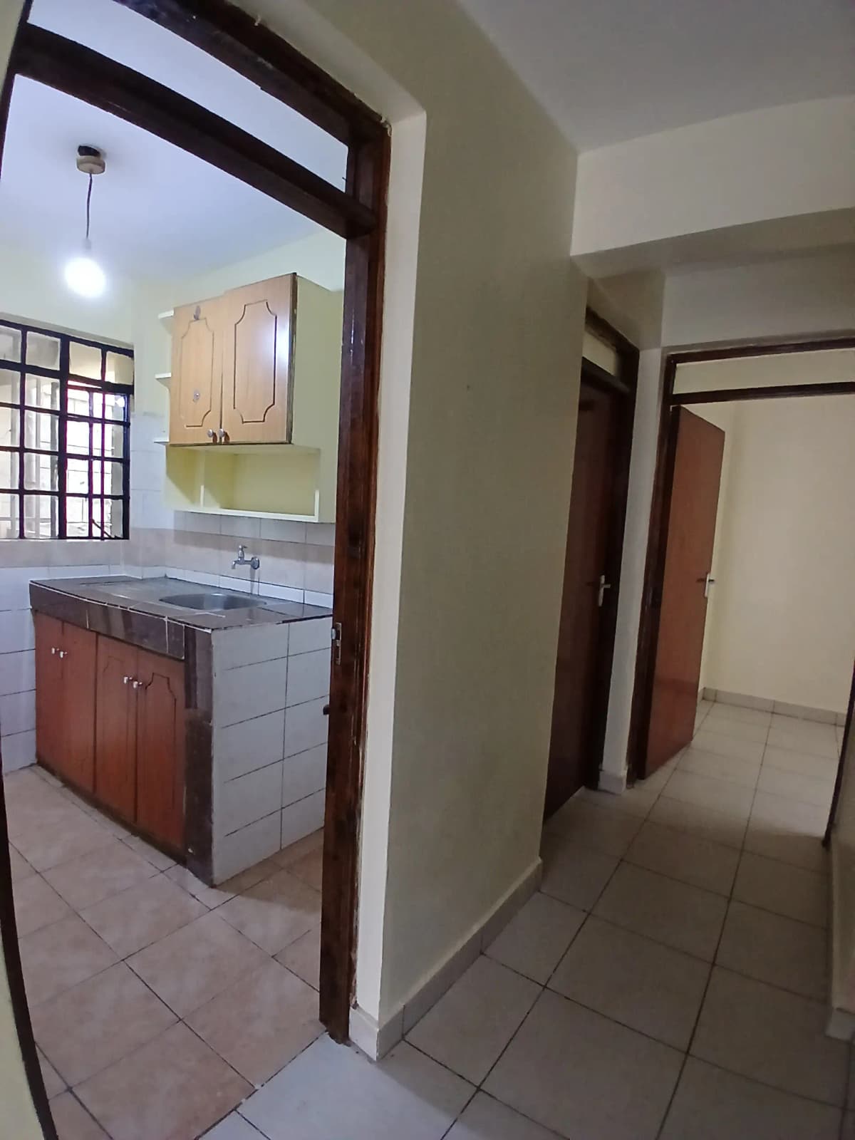 Hallway with view into kitchen area with red cabinets