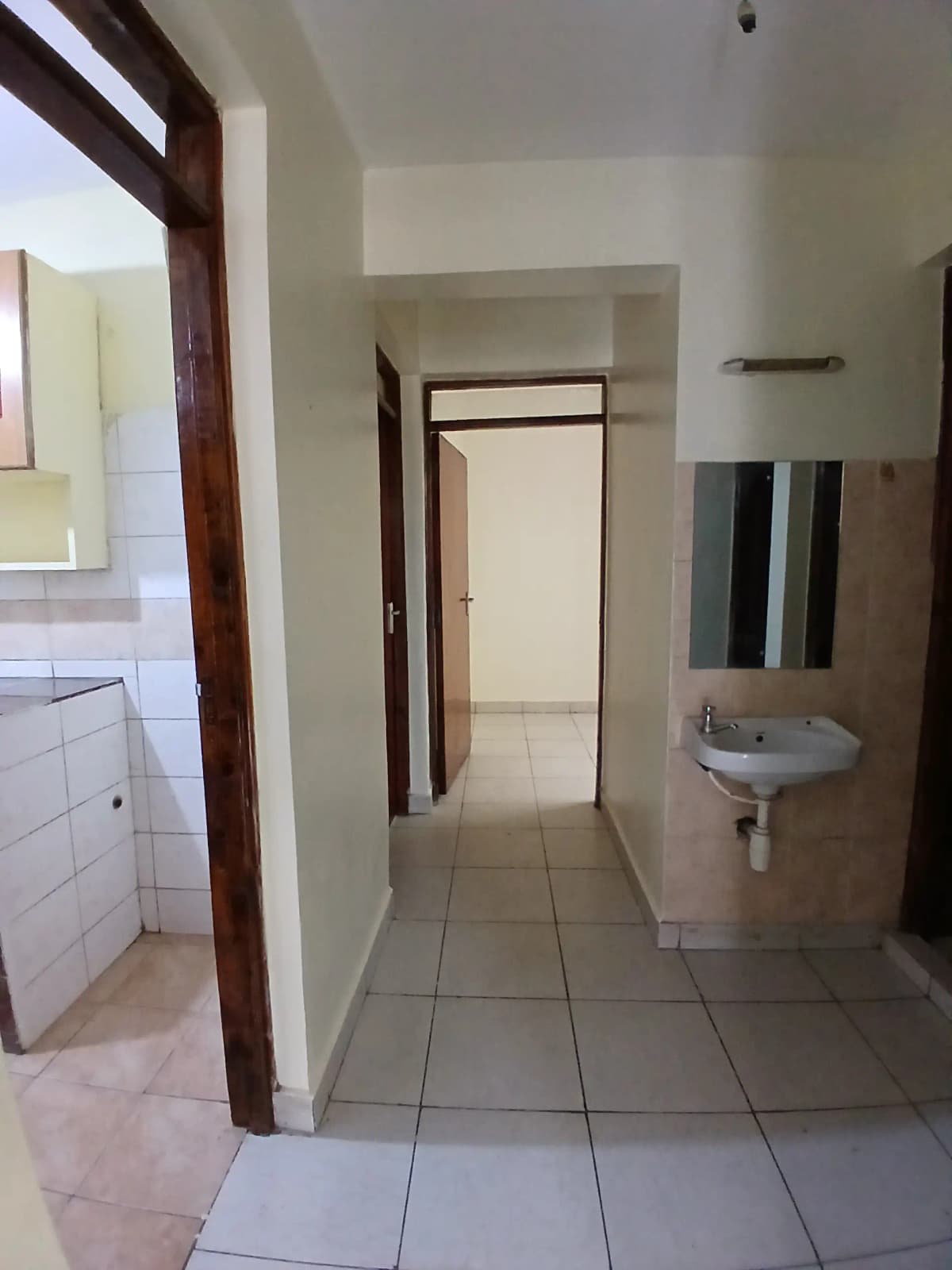 Tiled corridor with bathroom access and utility areas