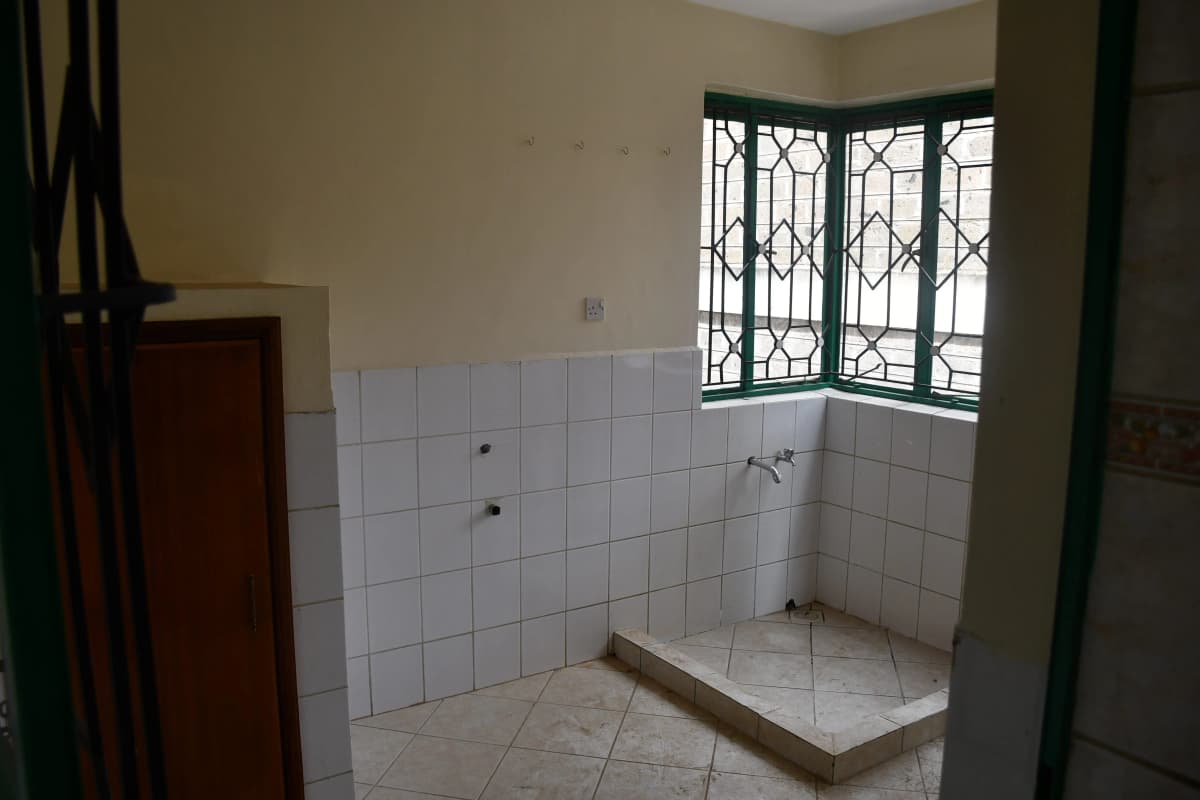 Basic bathroom with white tile walls and shower platform