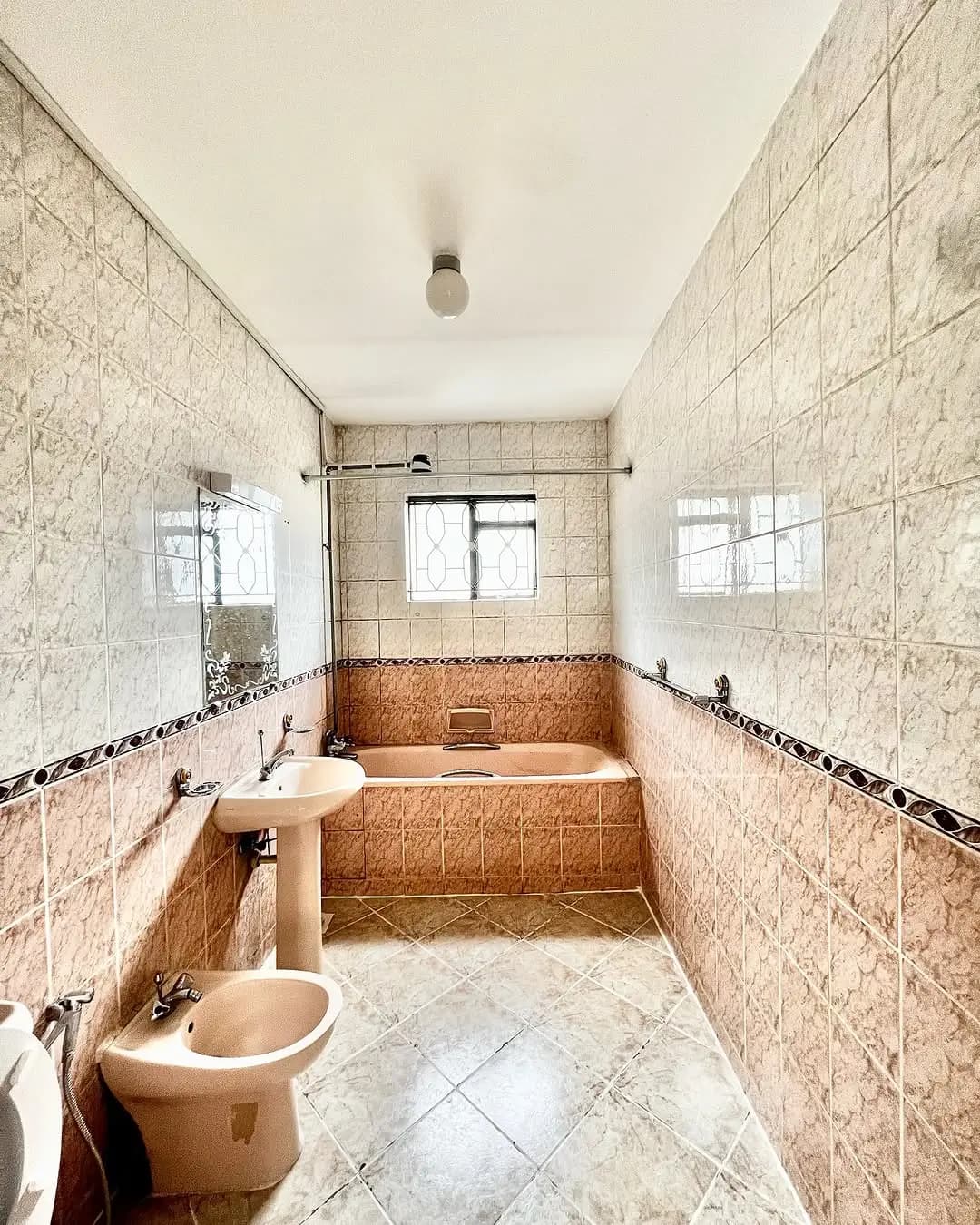 Spacious bathroom with sunken bathtub and dual windows