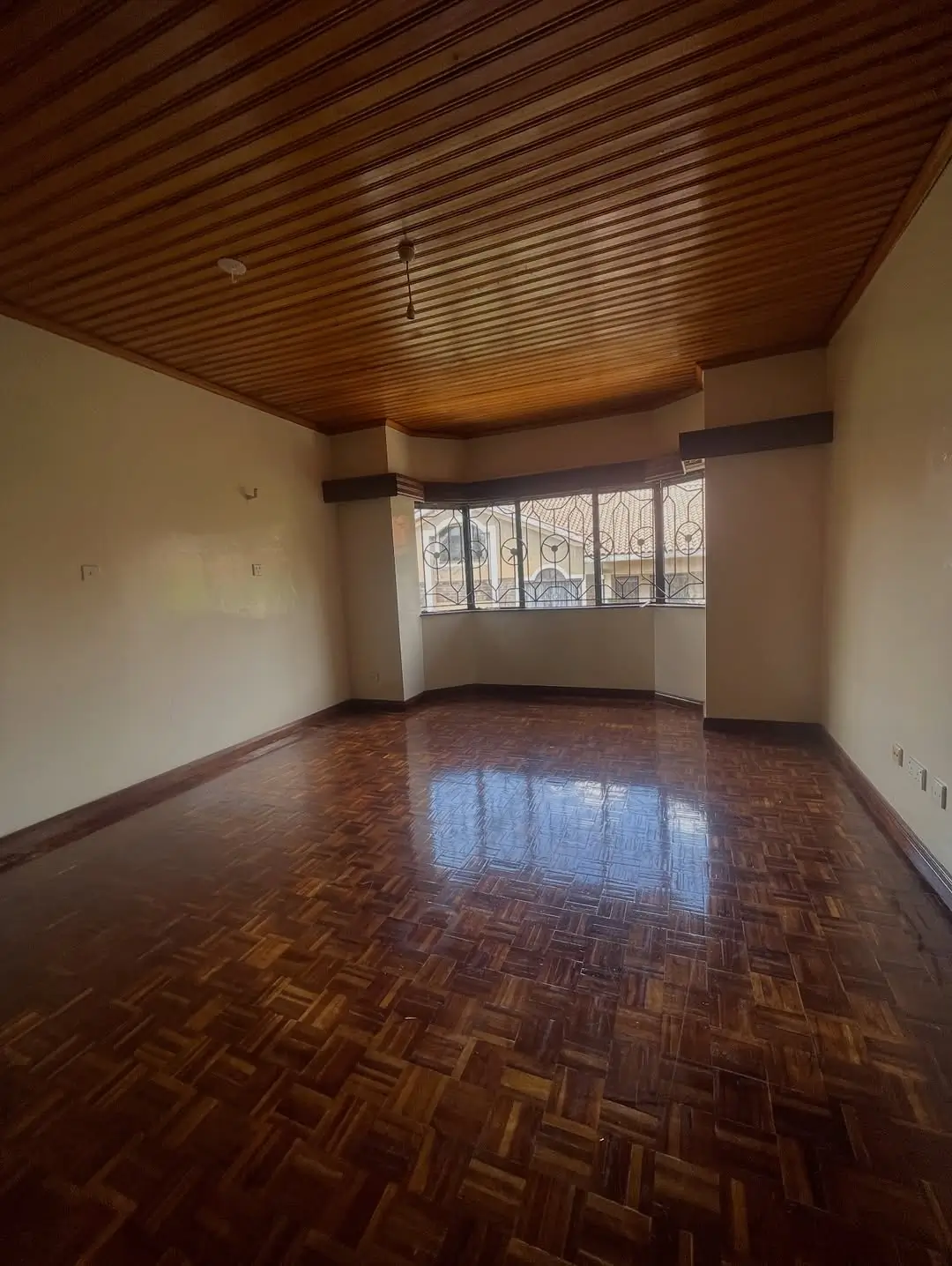 Spacious living room with wooden ceiling and herringbone flooring
