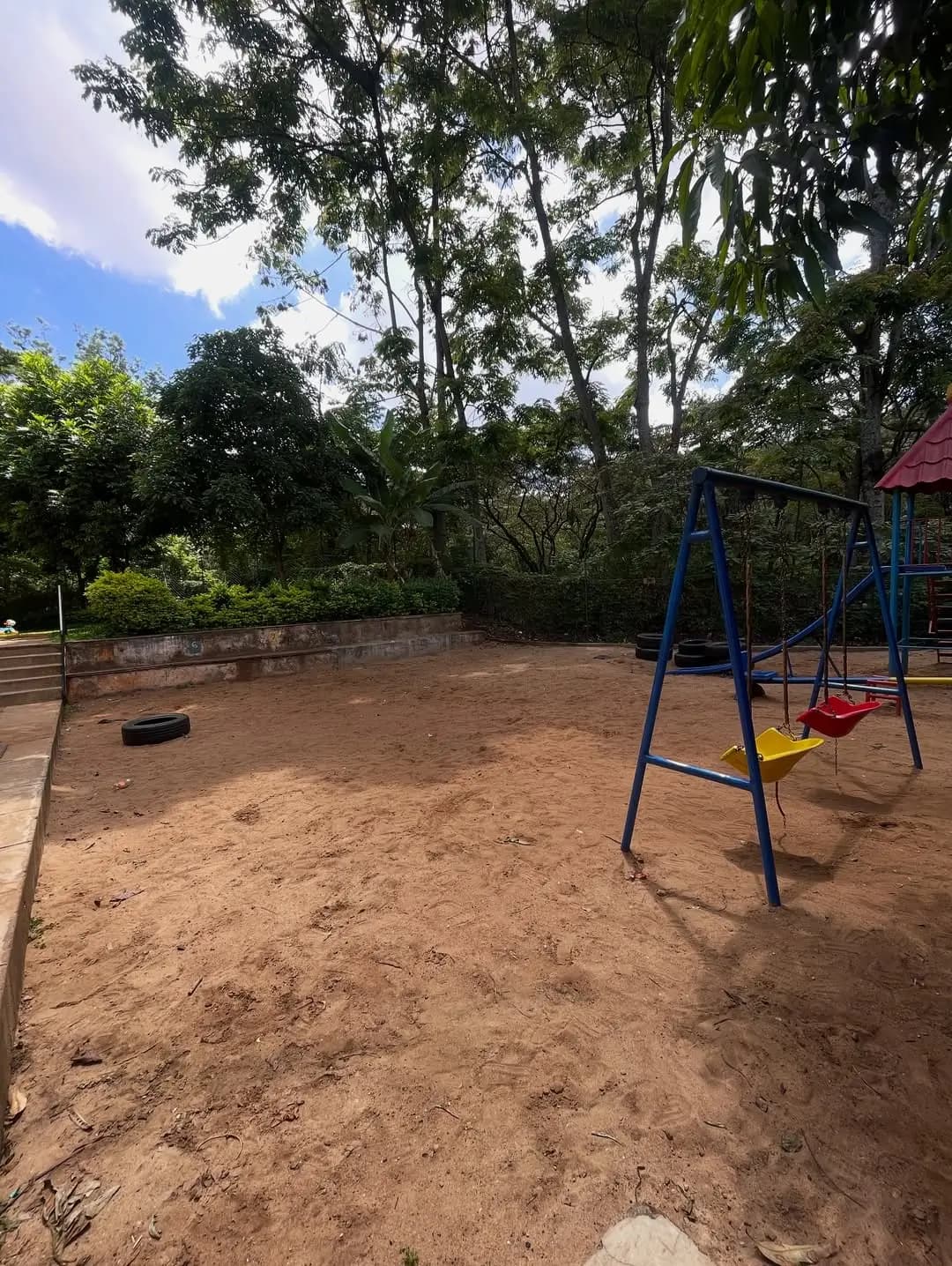Compound grounds with playground equipment and mature trees