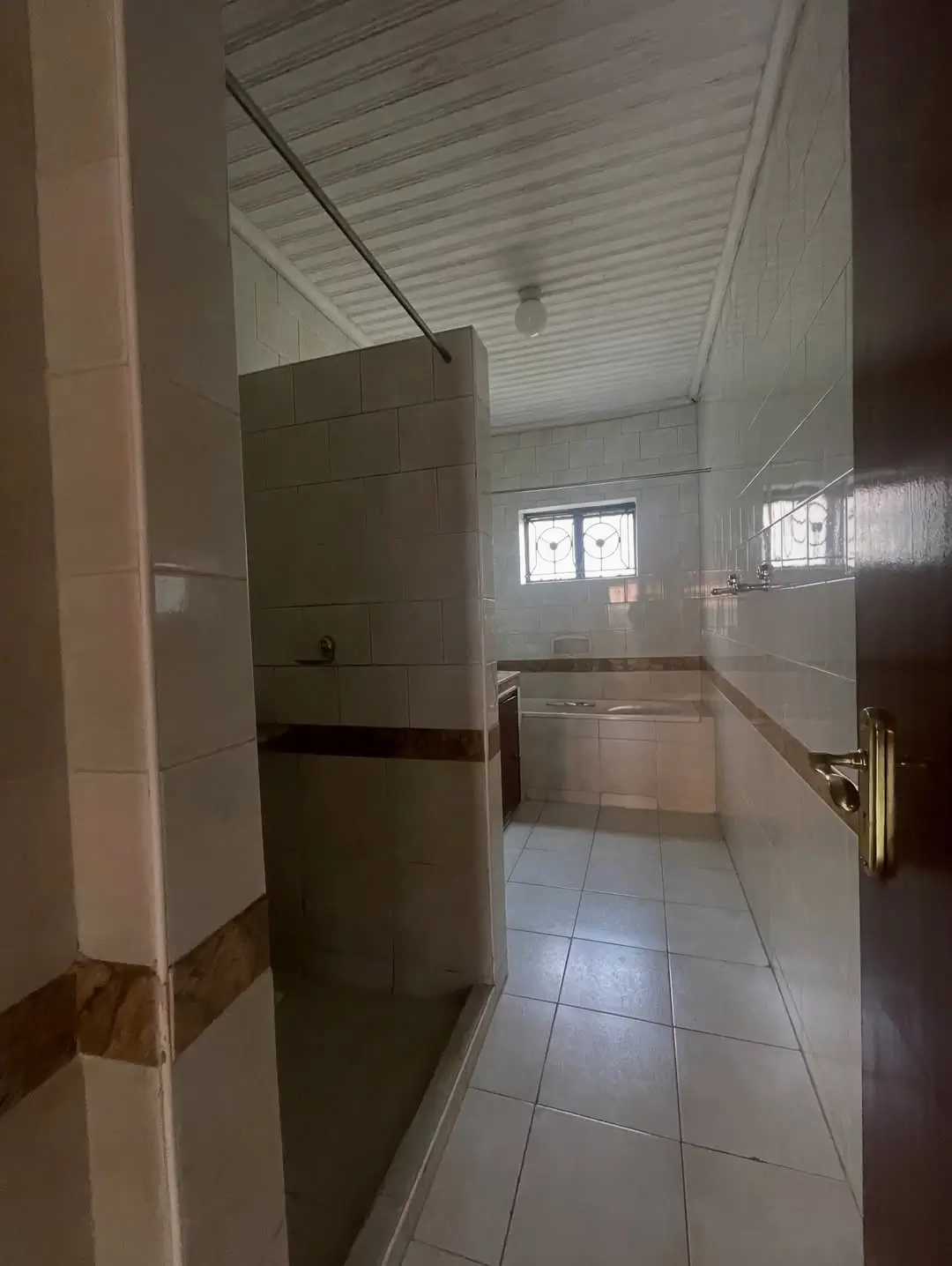 Clean bathroom with shower enclosure and tiled flooring
