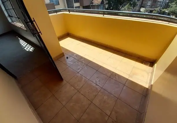 Bright yellow-painted balcony with tiled flooring and city views