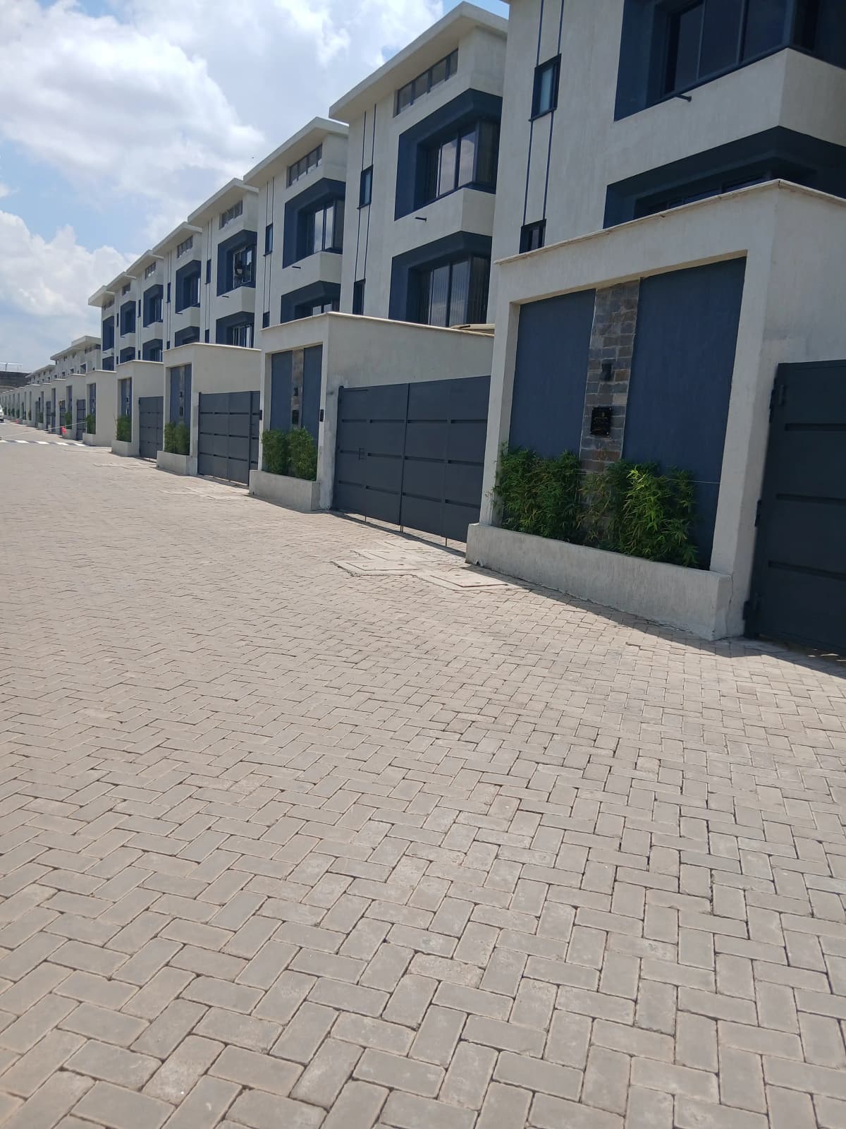 Modern townhouse row with integrated garage doors and paved driveway