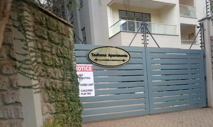 Building entrance with blue metal gate and ivy-covered wall