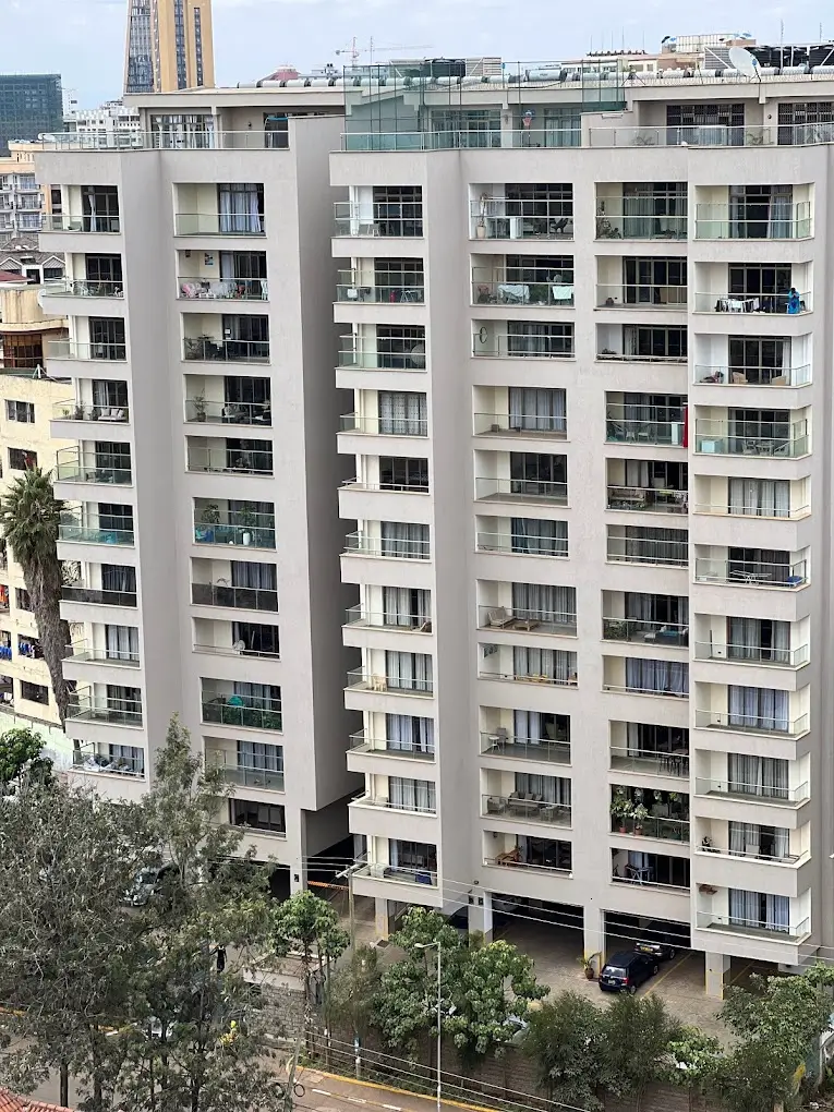 Multi-story residential building facade with balconies and parking