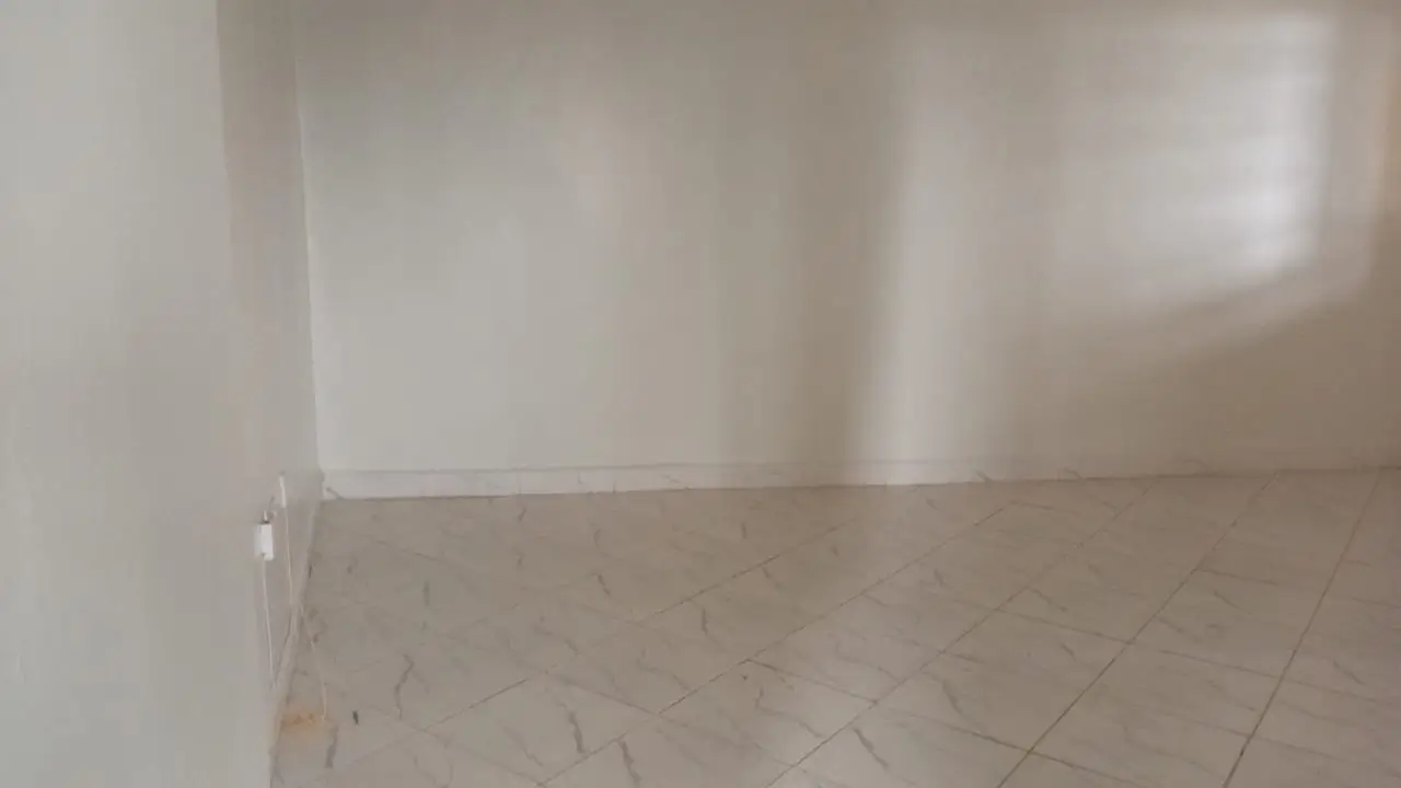 Empty room with tiled flooring and white walls