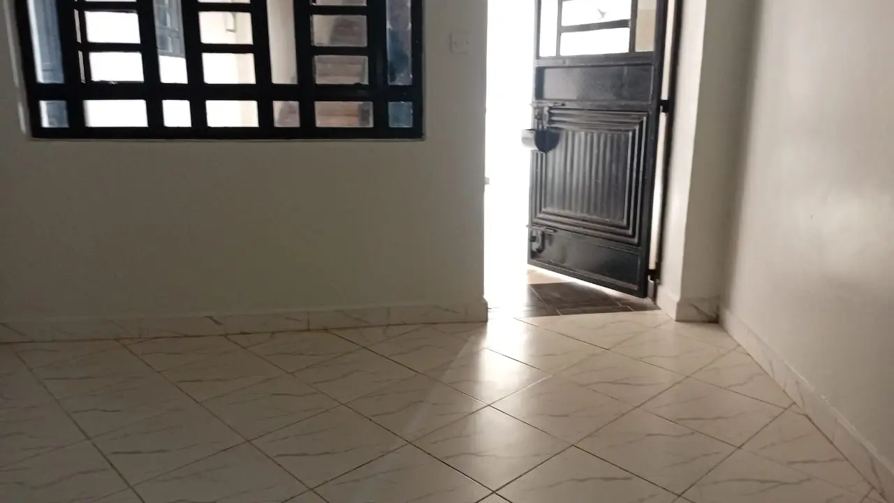 Bright hallway with tiled flooring and metal gate door