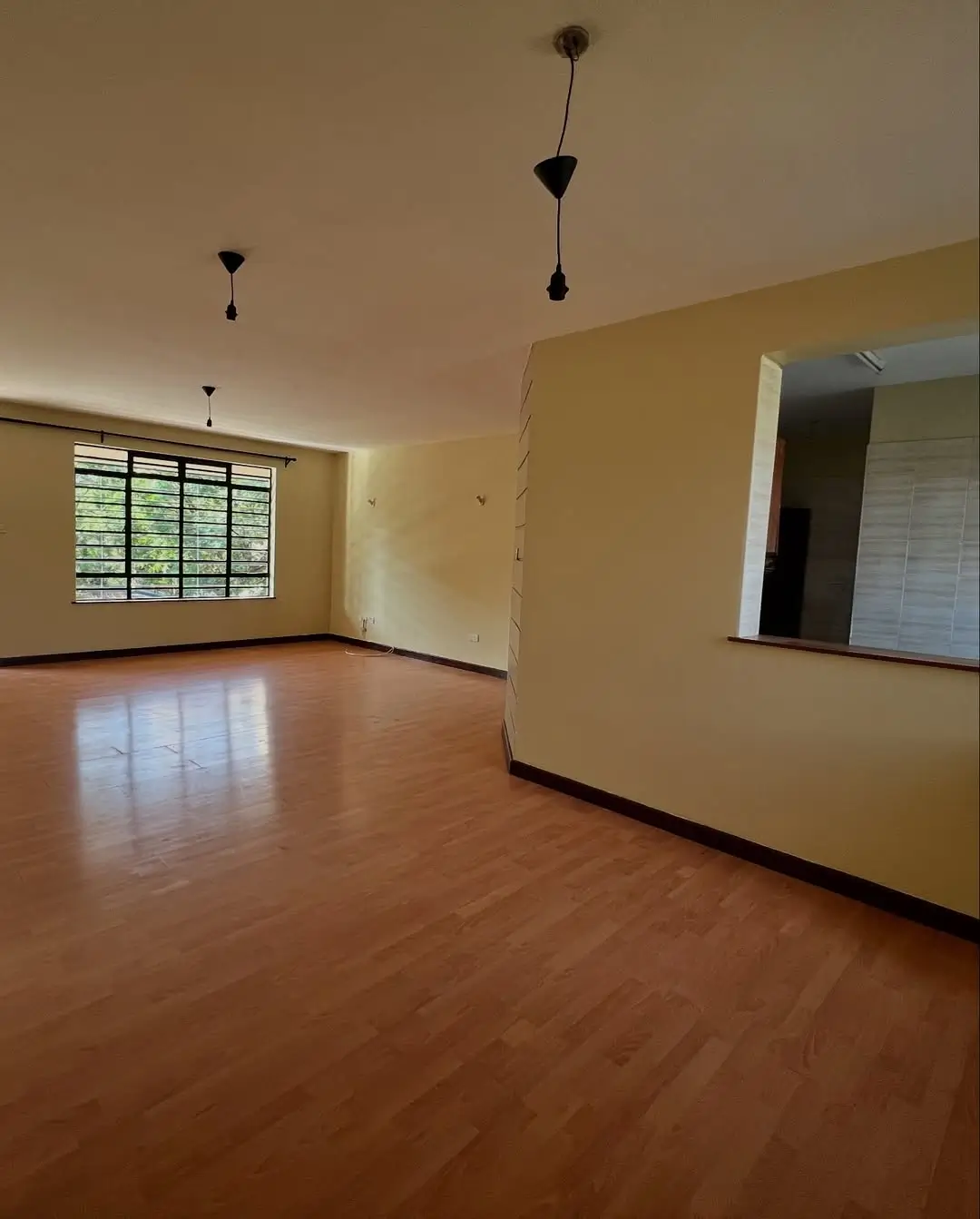 Spacious living room with wooden flooring and natural light