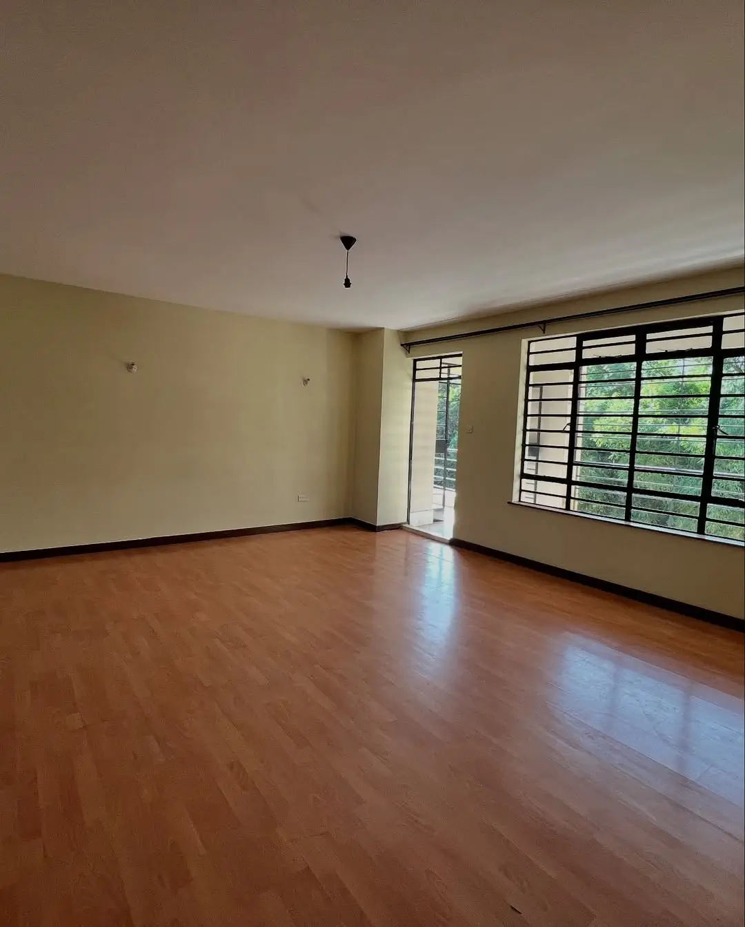 Spacious living room with polished wooden floor and natural light