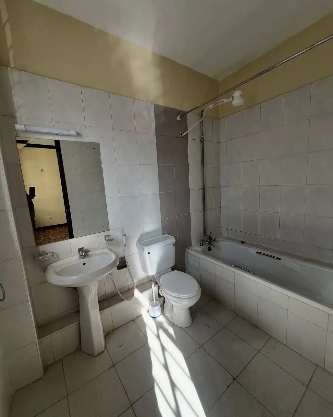 Bright bathroom with pedestal sink, toilet, and bathtub