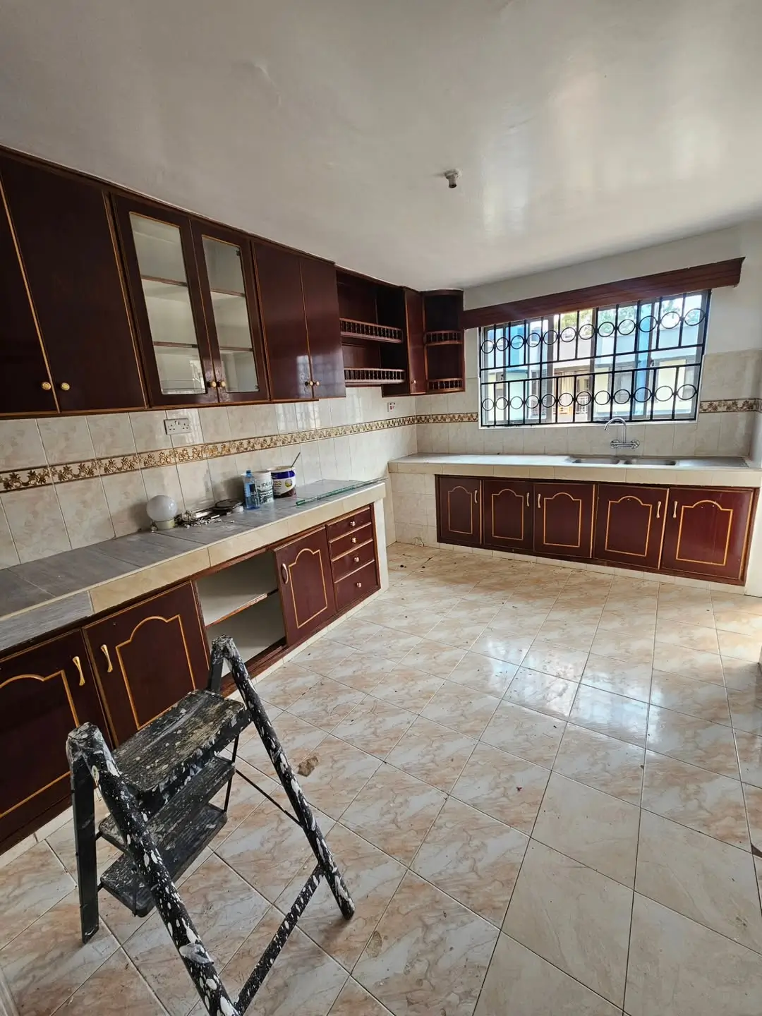 Spacious kitchen with dark wooden cabinets and marble countertops