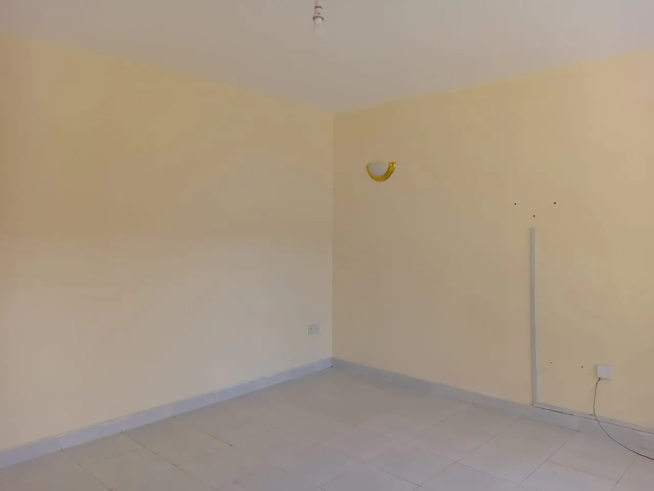 Empty bedroom with cream walls and concrete floor