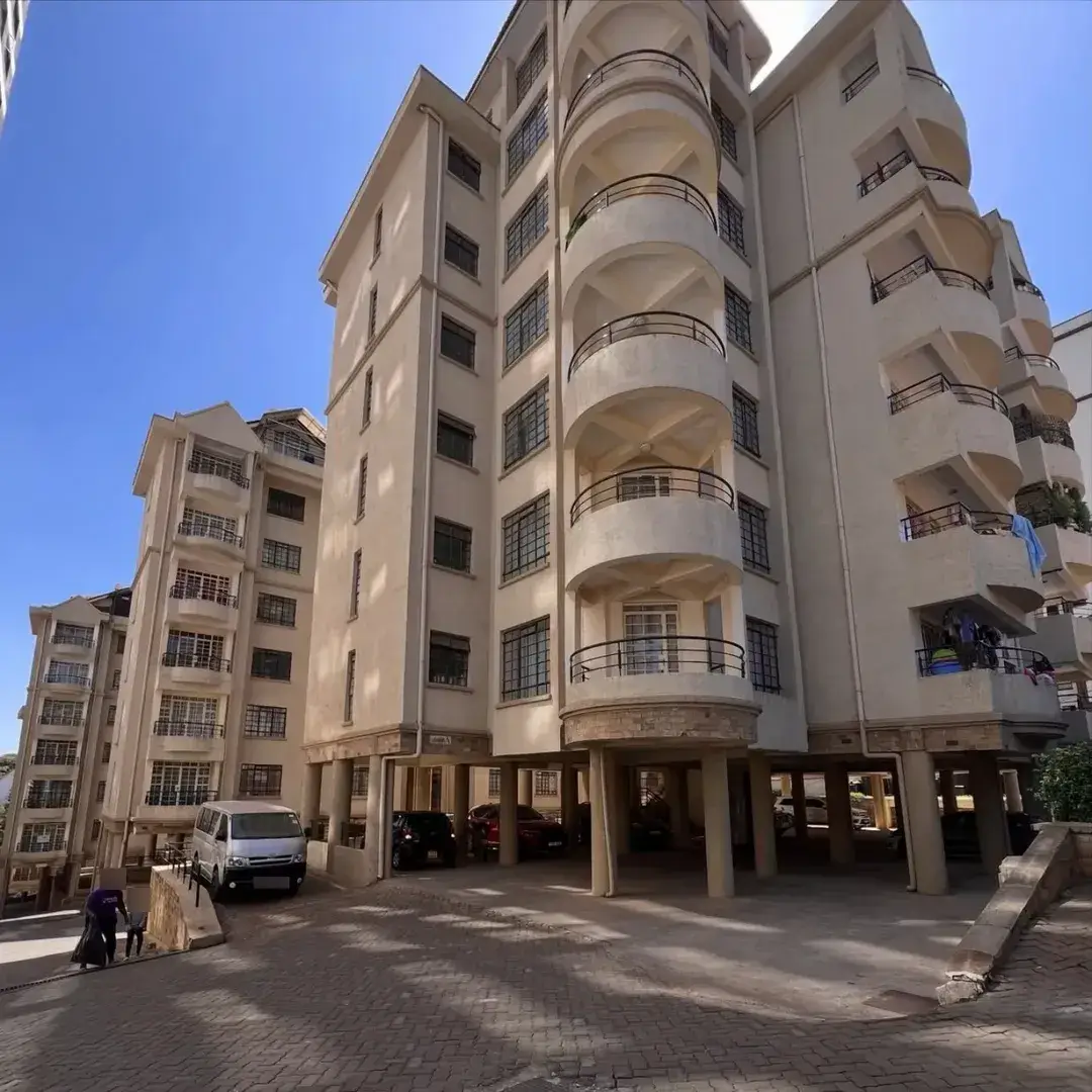 Multi-story apartment building with ground-level parking bays