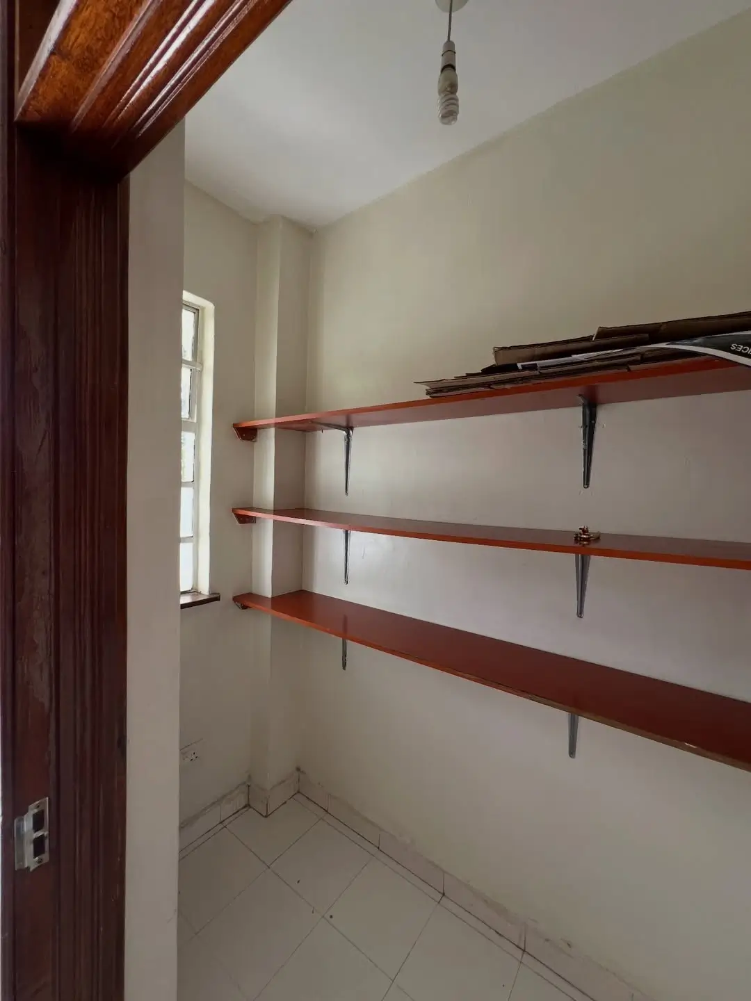 Empty pantry with wooden shelving and small window
