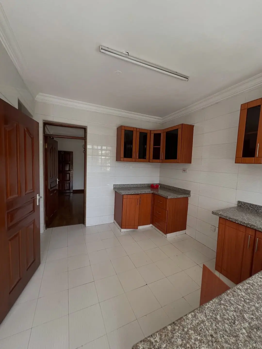Spacious kitchen with wooden cabinets, granite countertops, tiled floor