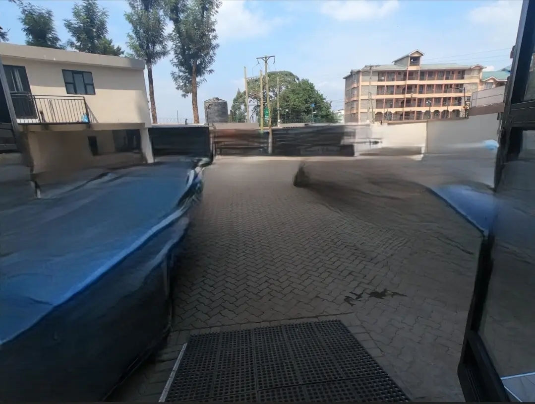 Covered parking area with paved ground and blue barriers