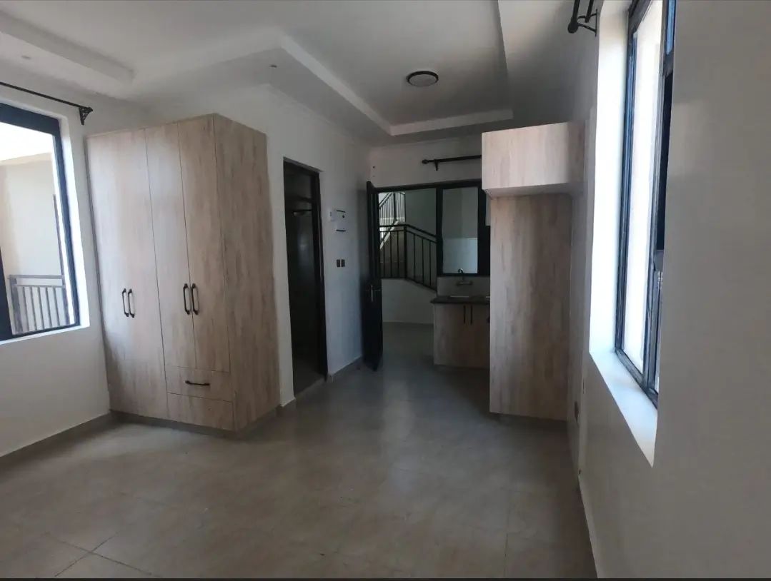 Bright corridor with built-in wardrobes and polished flooring