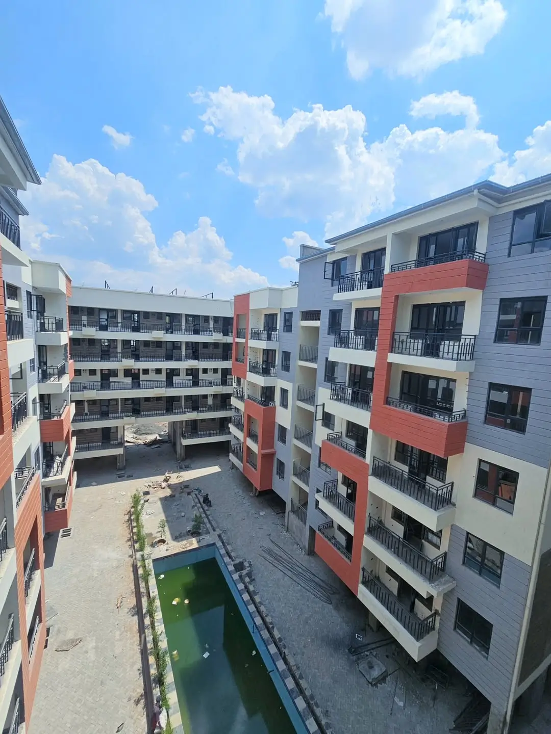 Modern multi-story residential complex with red and white facade