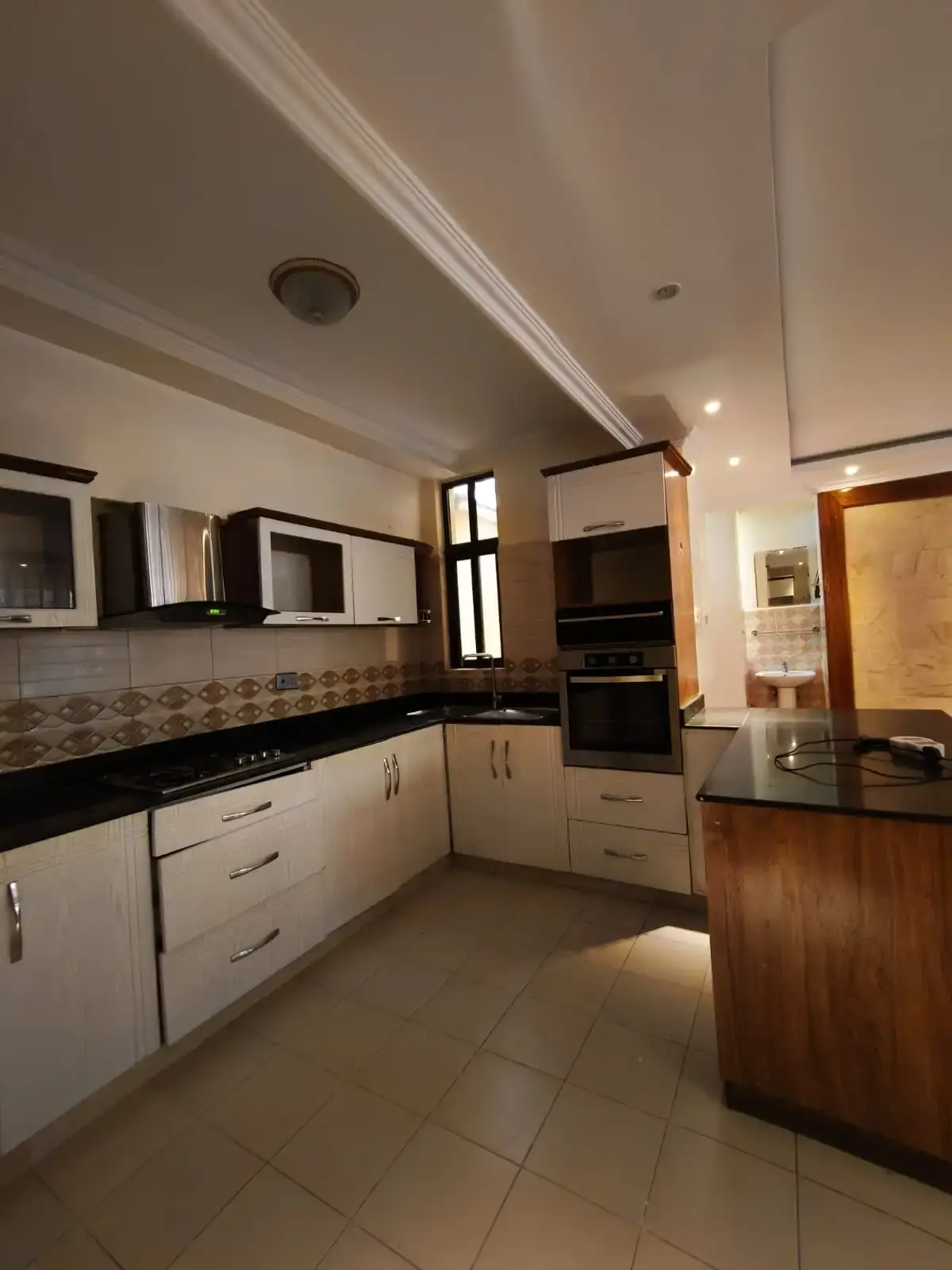Modern kitchen with white cabinetry, island counter, and dining area