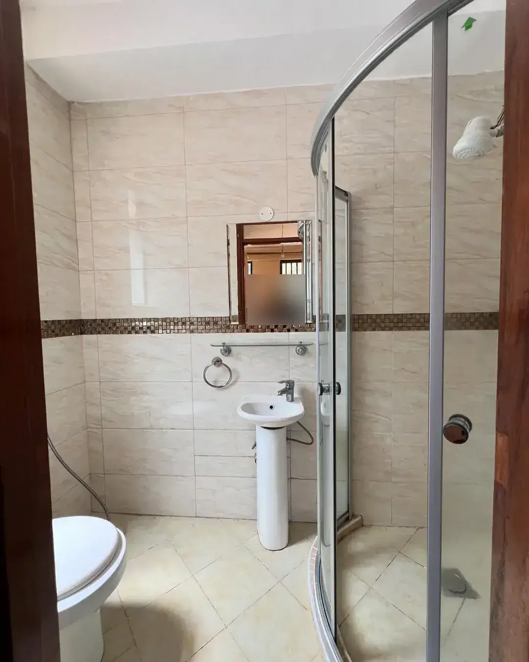 Modern bathroom with shower cubicle, pedestal sink, toilet