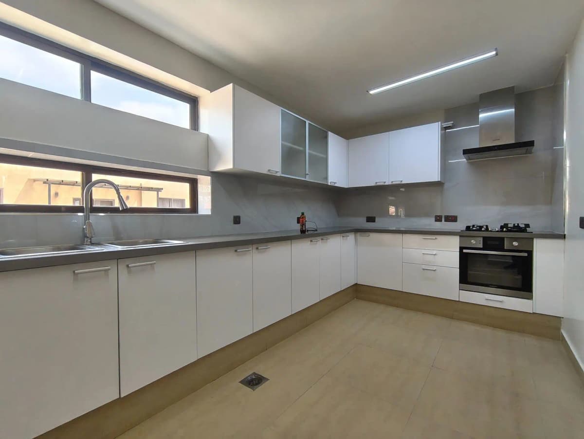 Modern white kitchen with gray countertops and built-in appliances