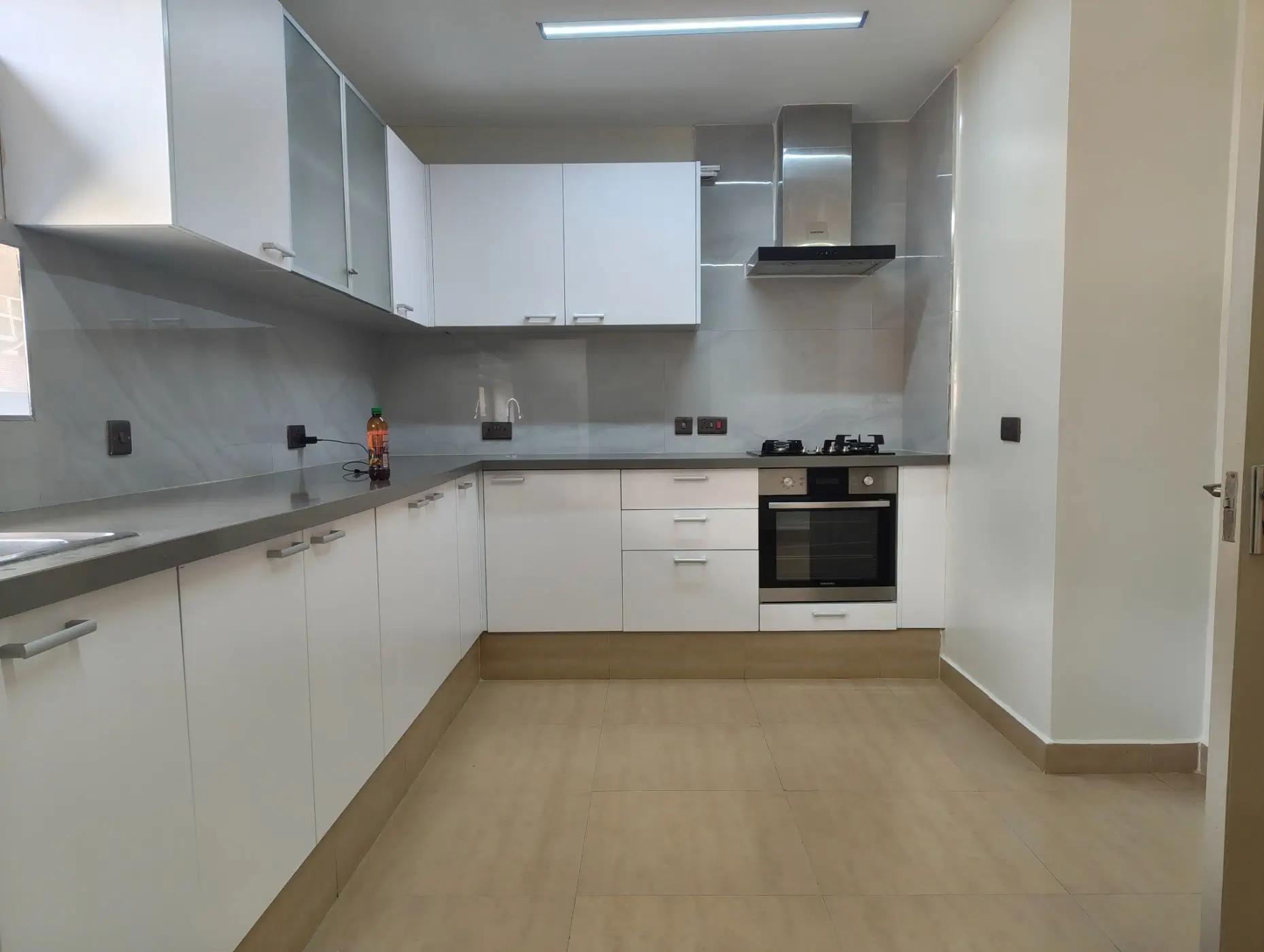 Modern white kitchen with built-in oven and gray countertops