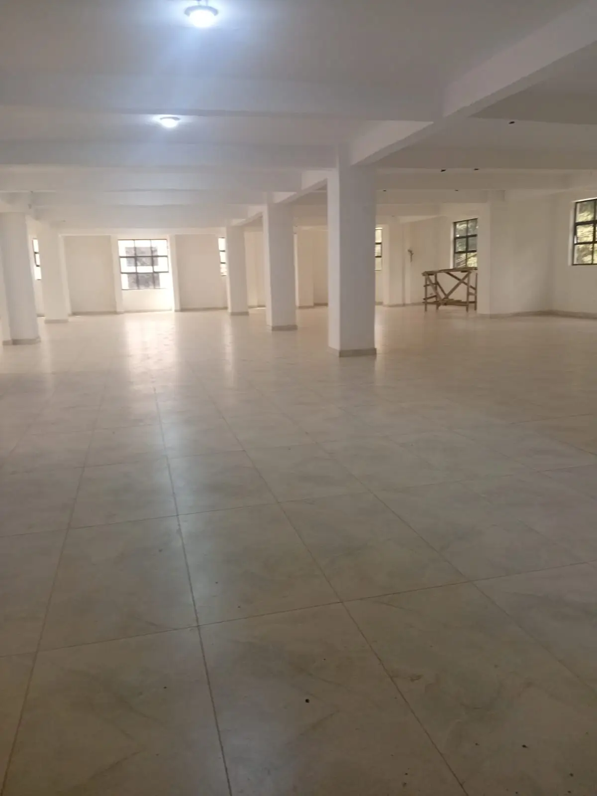 Spacious empty lobby with polished tile flooring and columns