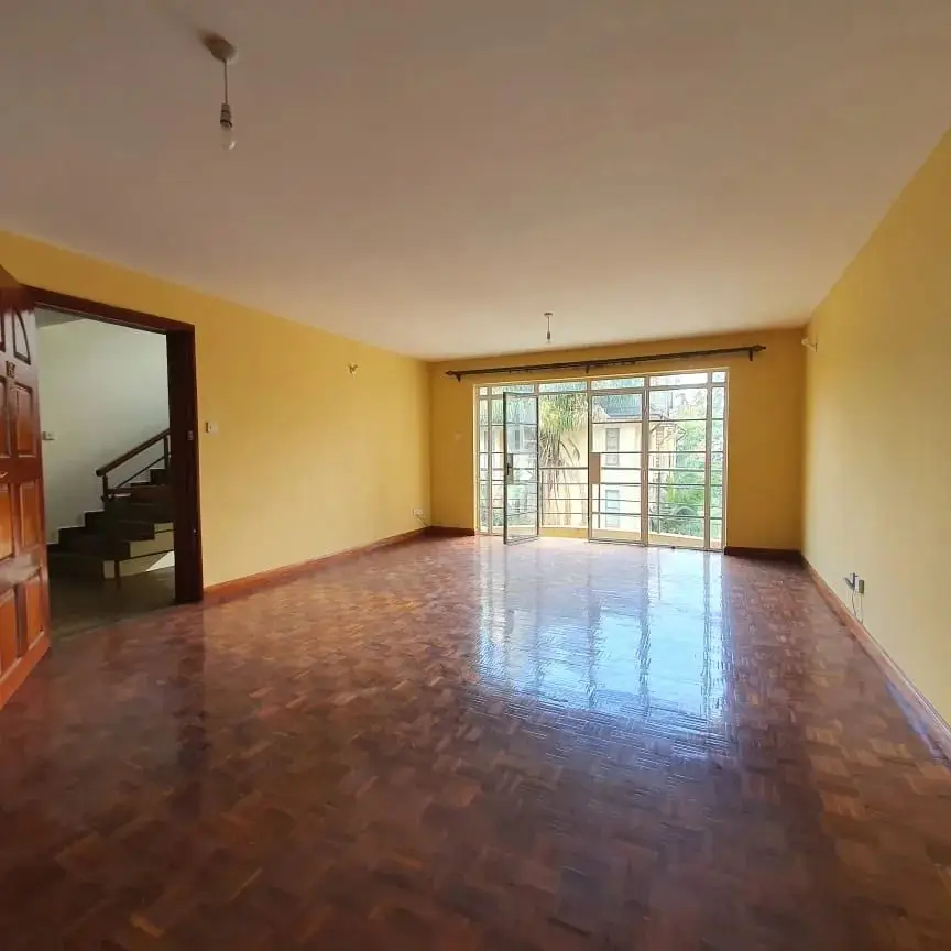 Bright yellow living room with polished wood floors and glass doors