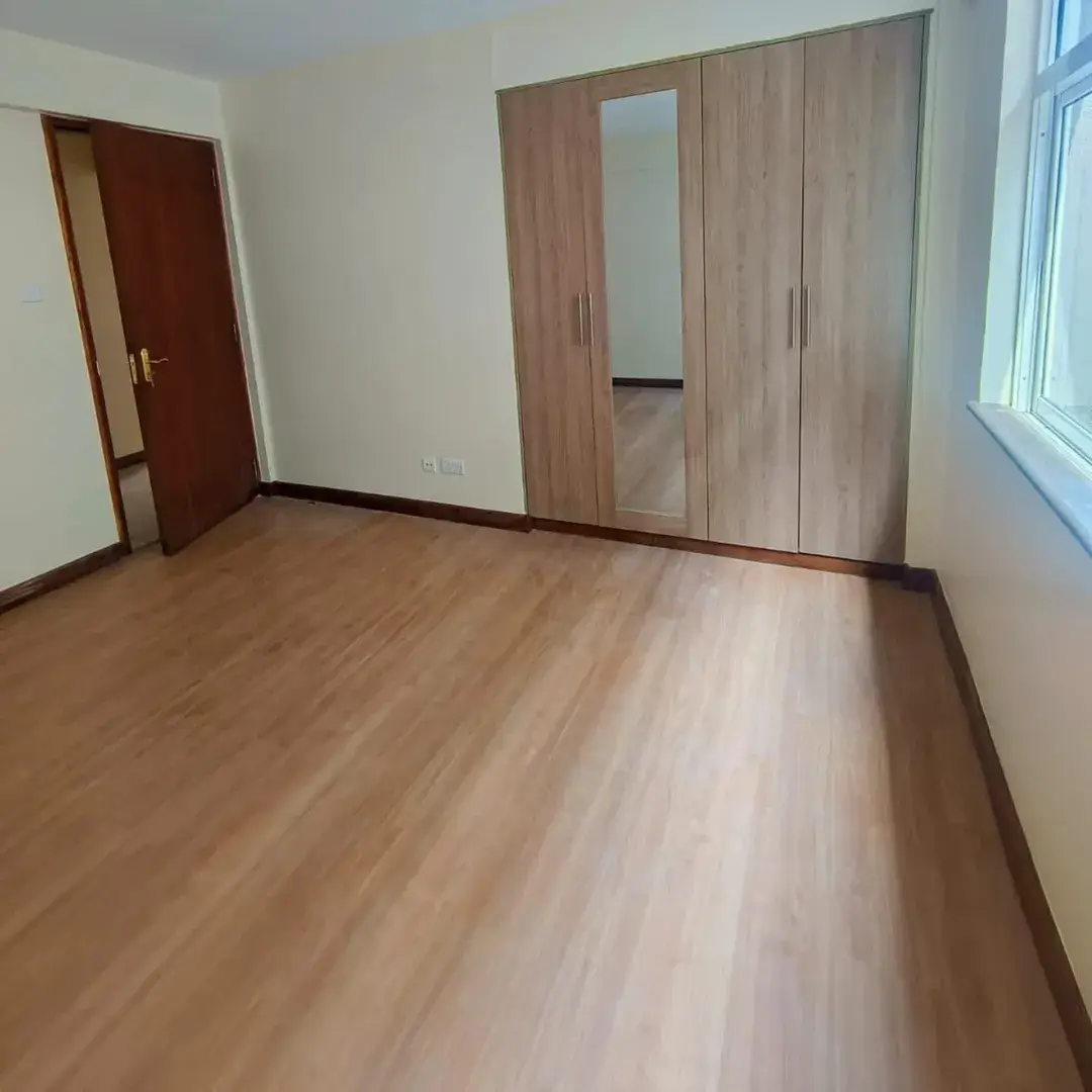 Spacious bedroom with wooden flooring and built-in wardrobe