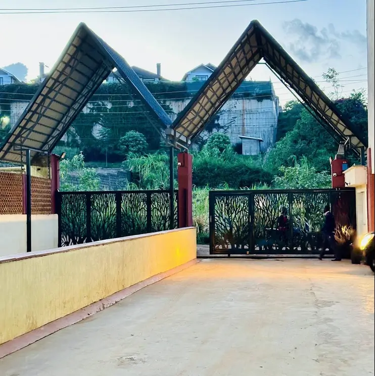 Compound entrance with decorative gate and landscaped surroundings