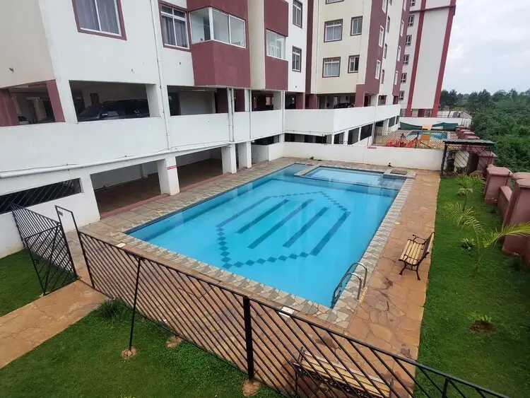 Rectangular swimming pool with lane markings and manicured grounds