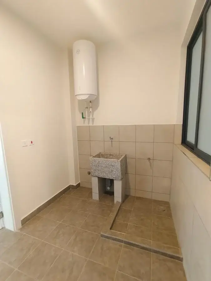 Basic bathroom with wall-mounted basin and water heater