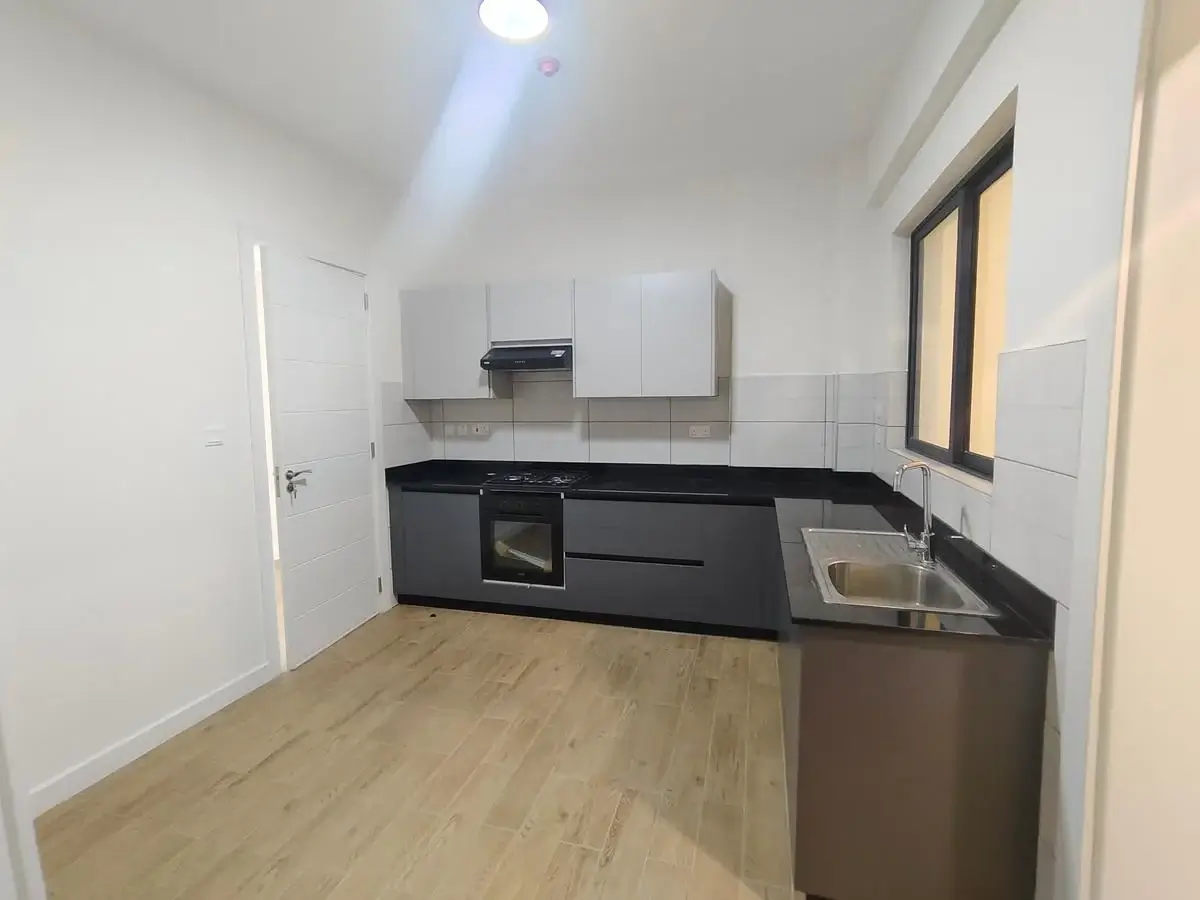 Modern kitchen with black countertops and built-in appliances