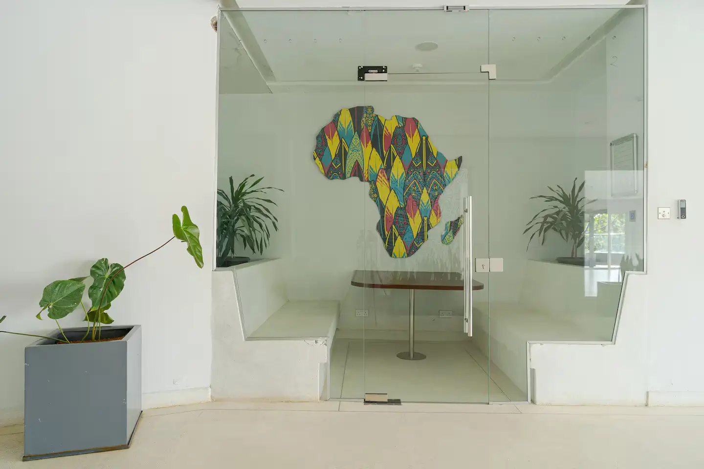Modern co working spaces with frosted glass enclosure and colorful African map art