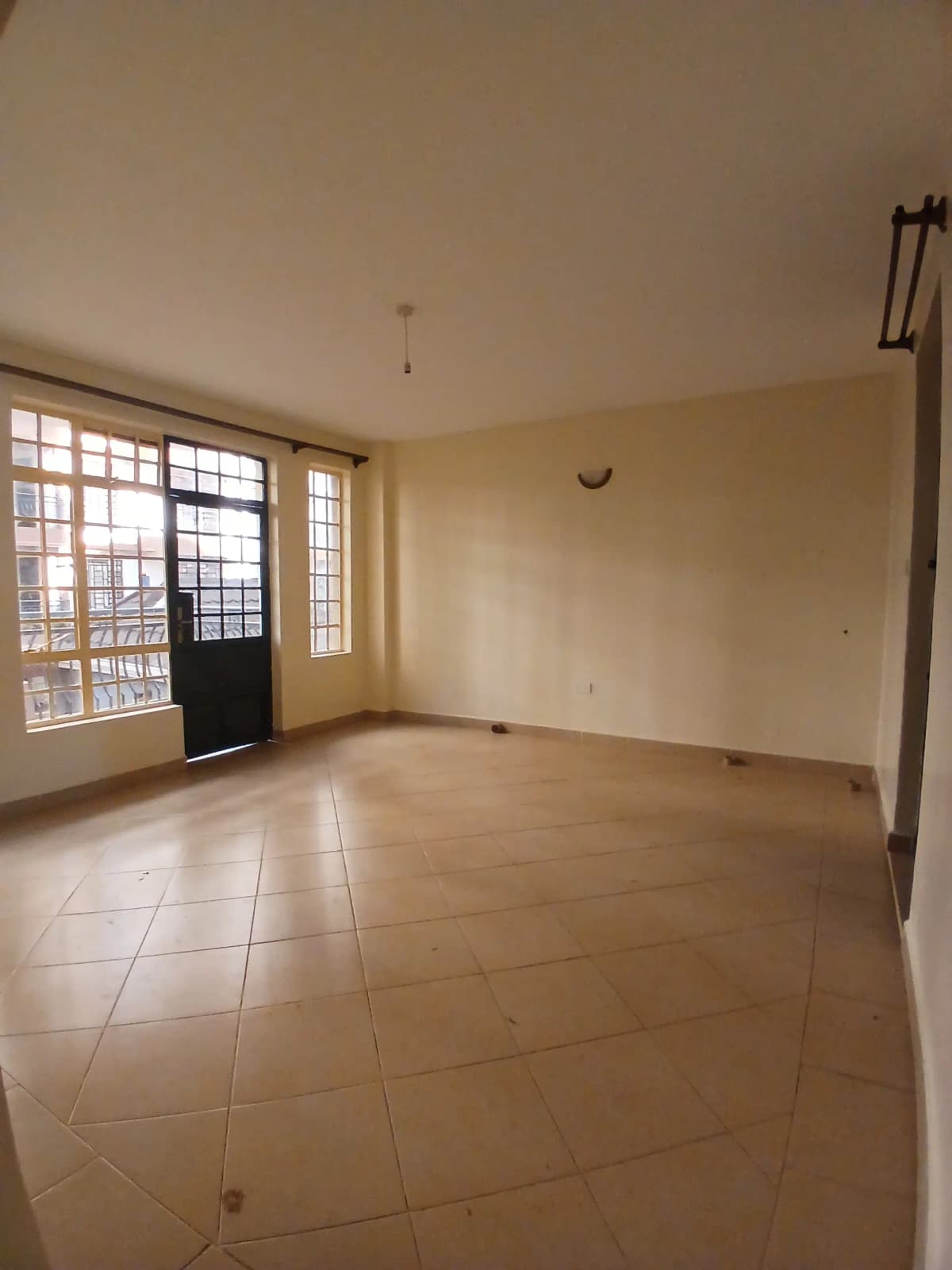 Spacious living room with tiled flooring and natural light