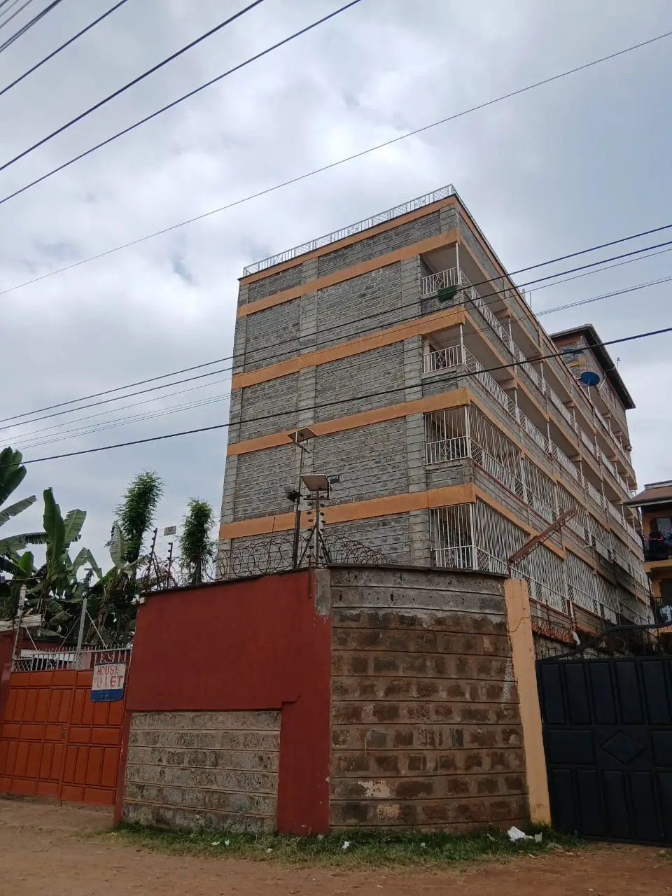 Multi-story residential building facade with stone and orange trim