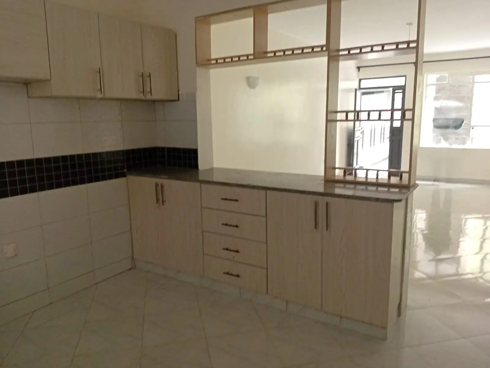 Modern kitchen with cream cabinets, black tile backsplash, granite counters