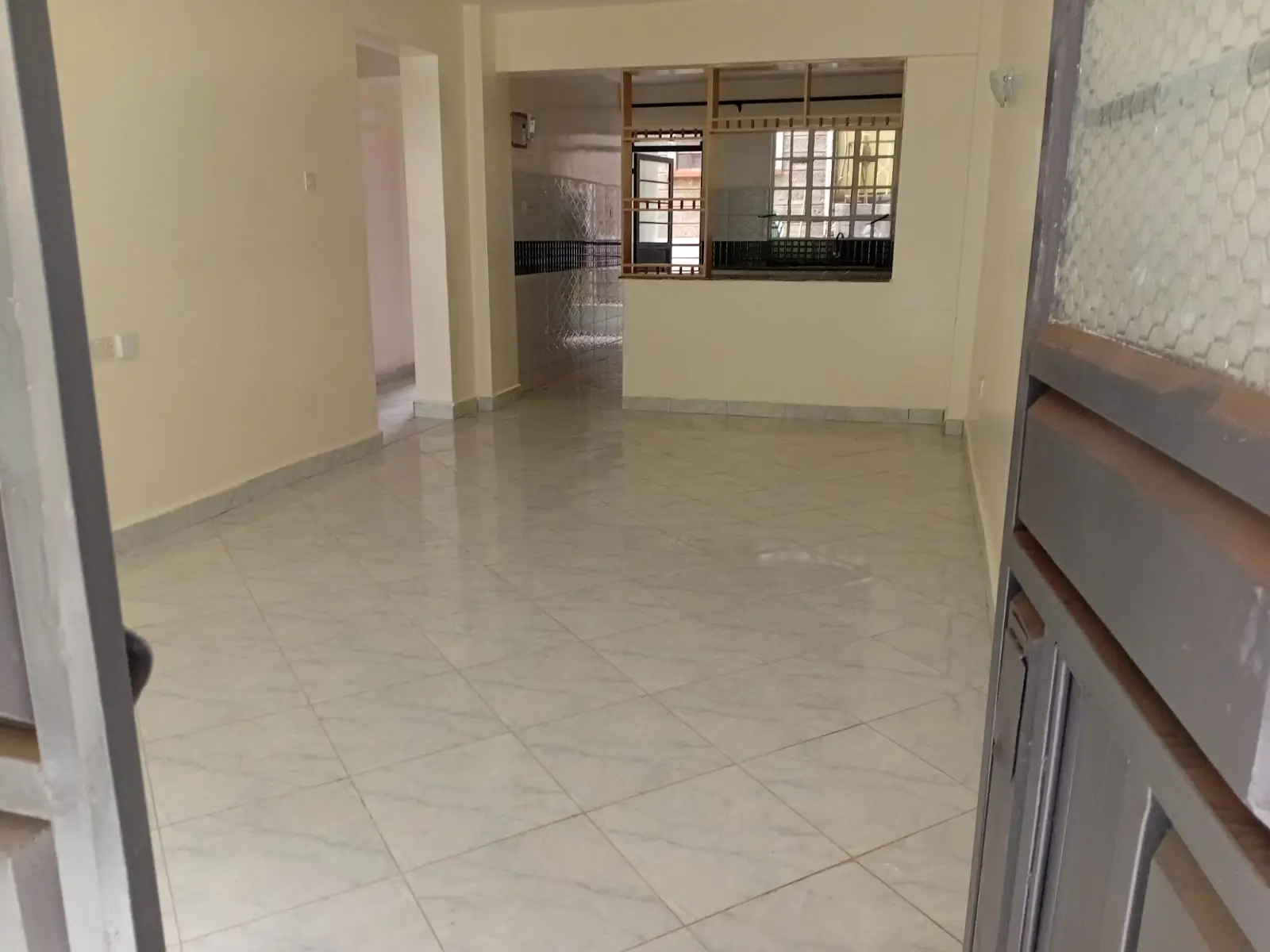 Spacious open-plan living area with polished tile flooring