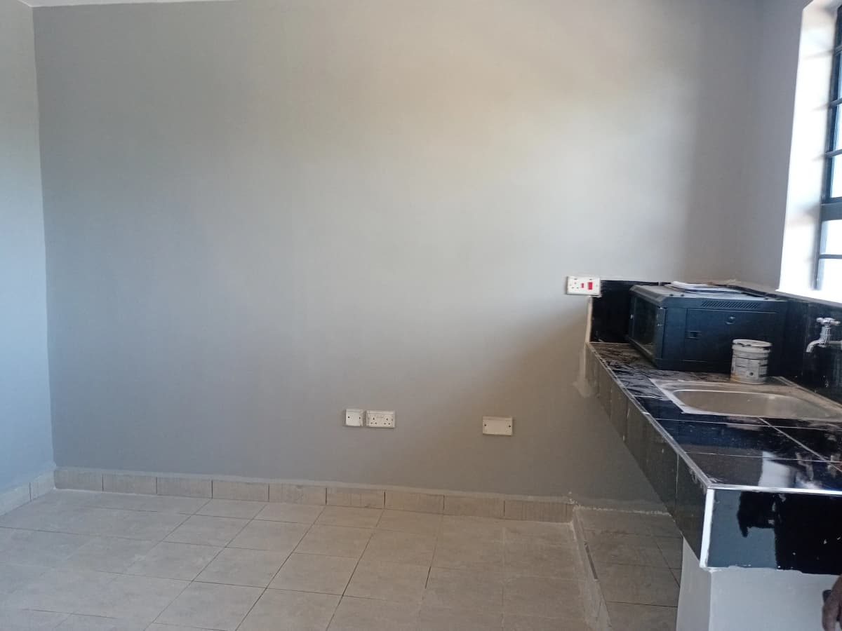 Minimalist kitchen with dark cabinetry and tiled flooring