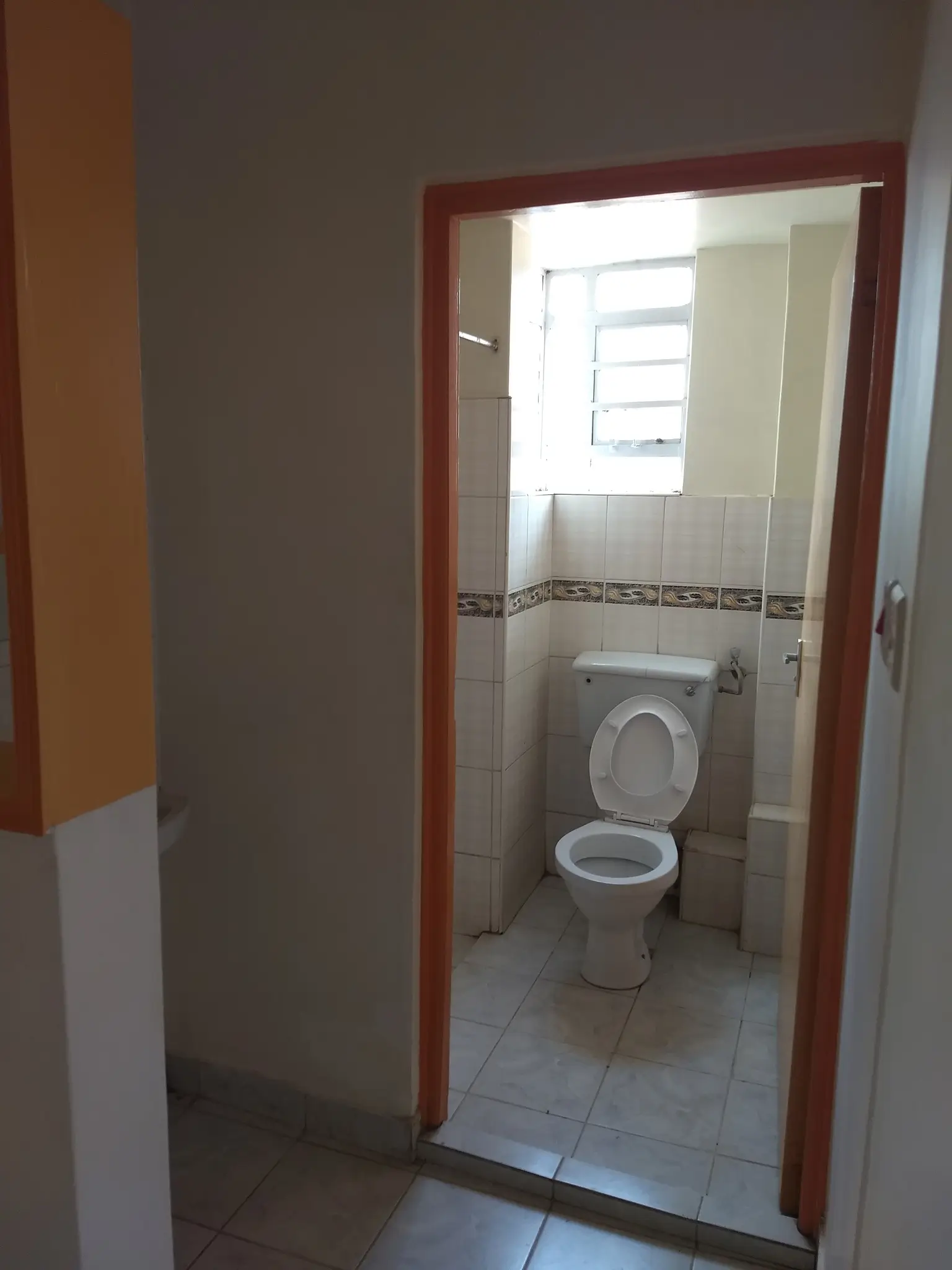 Compact bathroom with toilet and small window
