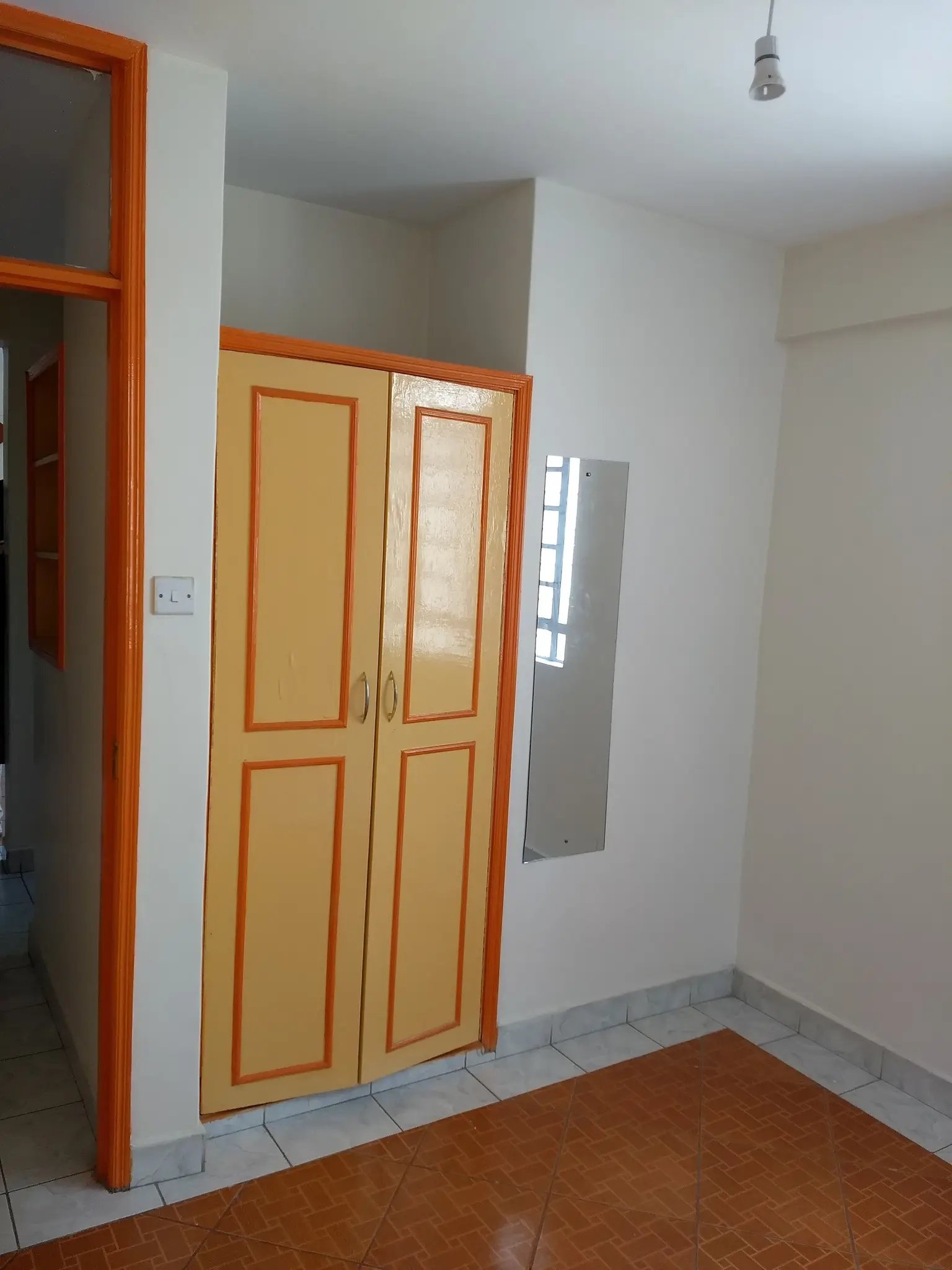 Hallway with wooden wardrobe doors and tile flooring