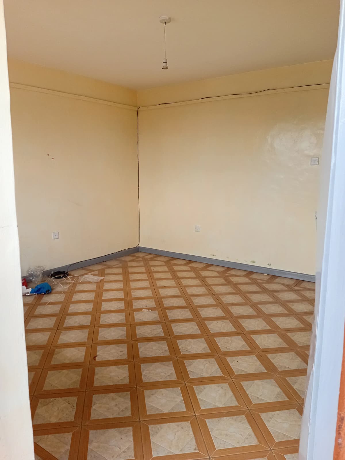 Empty bedroom with geometric tile flooring and bare walls