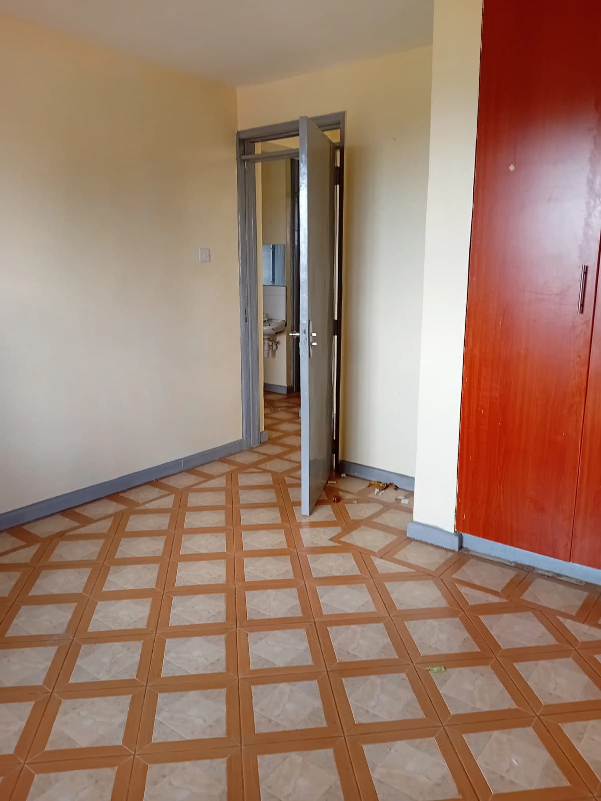 Corridor with geometric tile flooring and red accent door