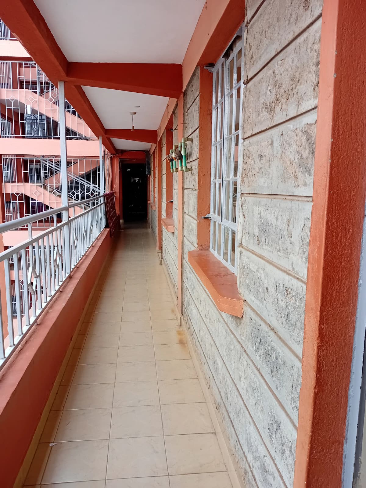 Building corridor with red beams and white railings