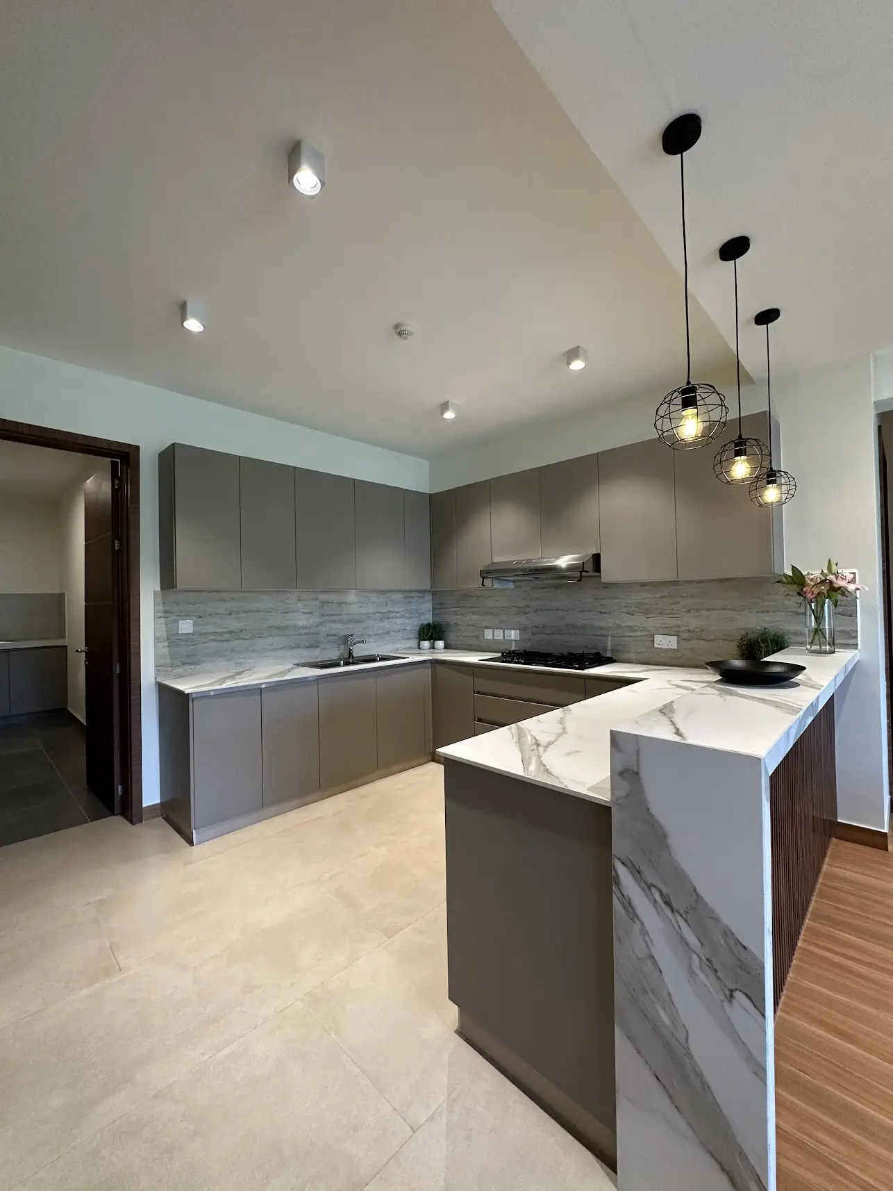 Modern gray kitchen with marble island and pendant lighting