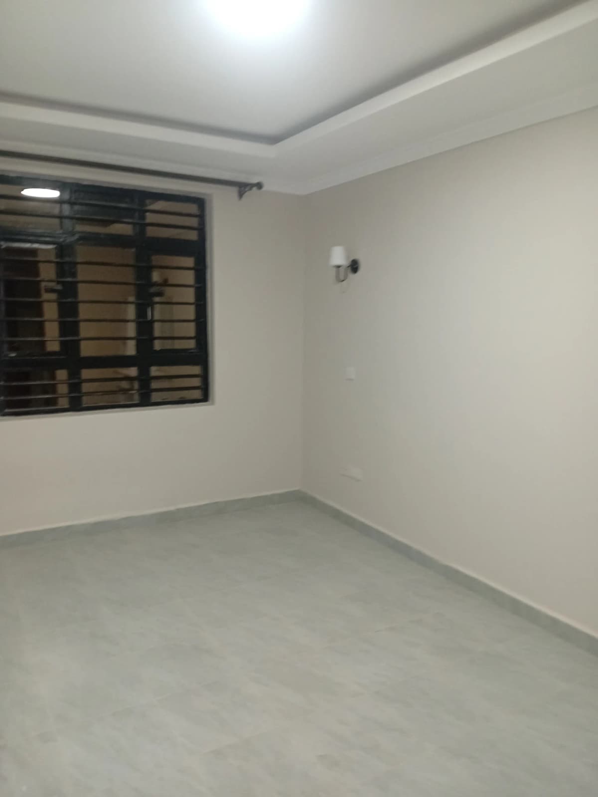 Empty bedroom with window and ceiling light fixture