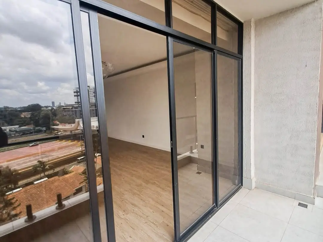 City skyline view from high-rise balcony with glass doors
